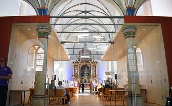 Auf dem Foto sieht man den Hochaltar der Kirche durch den Kubus hindurch.