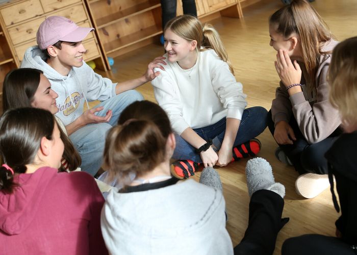 Junge Menschen sitzen zusammen in einem Sitzkreis.