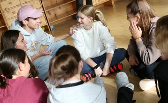 Junge Menschen sitzen zusammen in einem Sitzkreis.