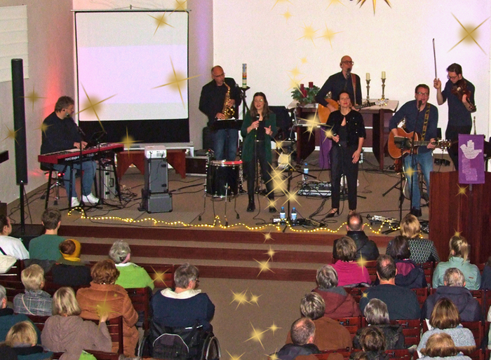 Acht Musikerinnen und Musiker stehen auf der Bühne und spielen vor einem Publikum in Dülmen.